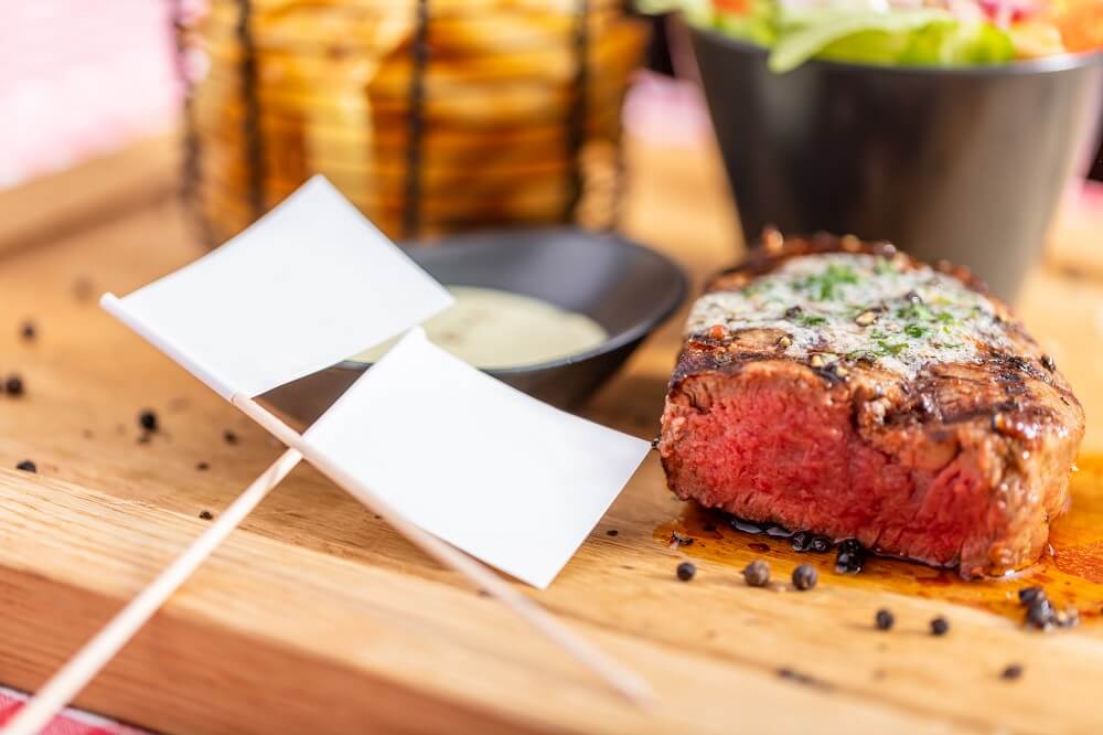 Beef steak meal and empty toothpick flags in an american restaurant